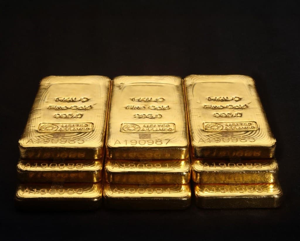 Üç sütunda üst üste dizilmiş kilogramlık ince altın külçeleri, damga ve seri numaraları